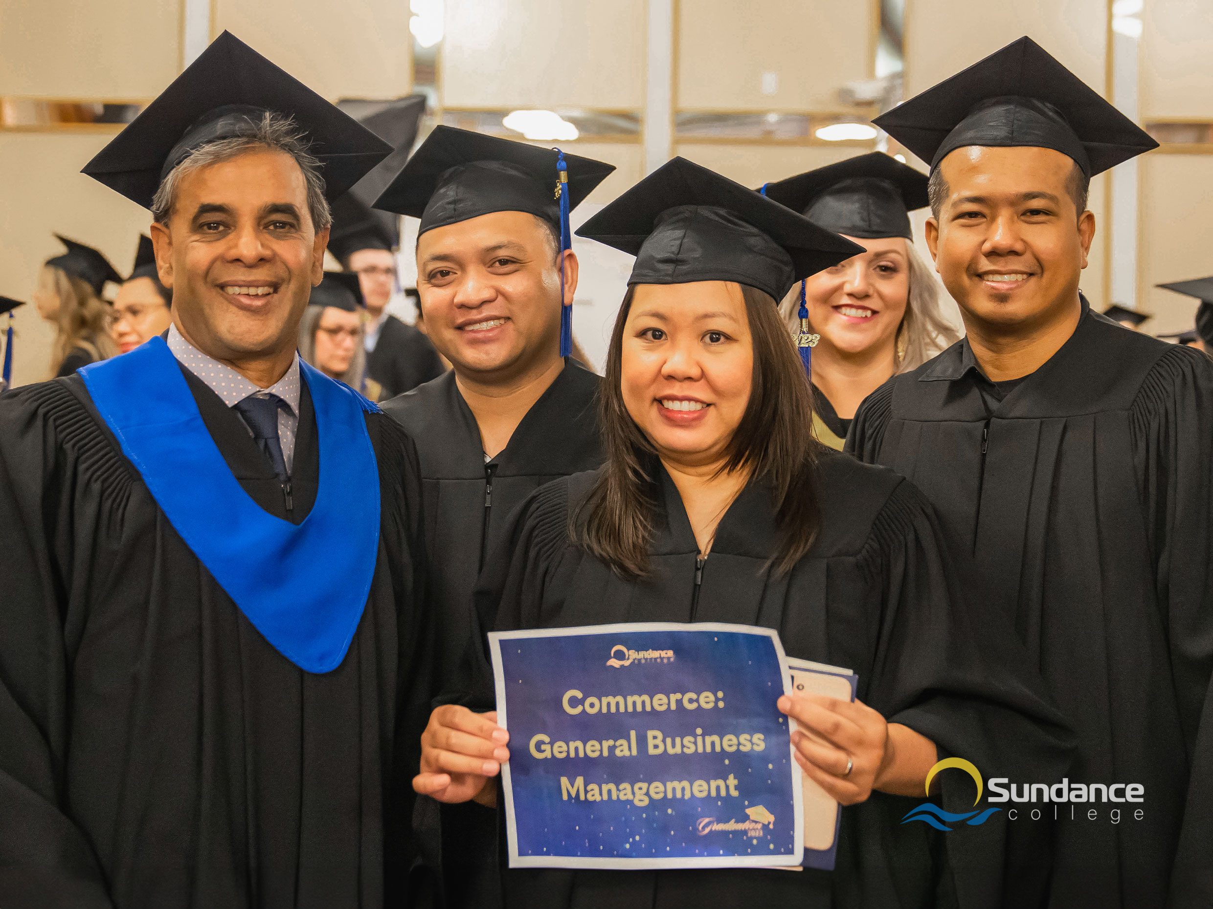 Sundance College's General Business Management instructor with three graduates at the gradution ceremony in Calgary, 2023.