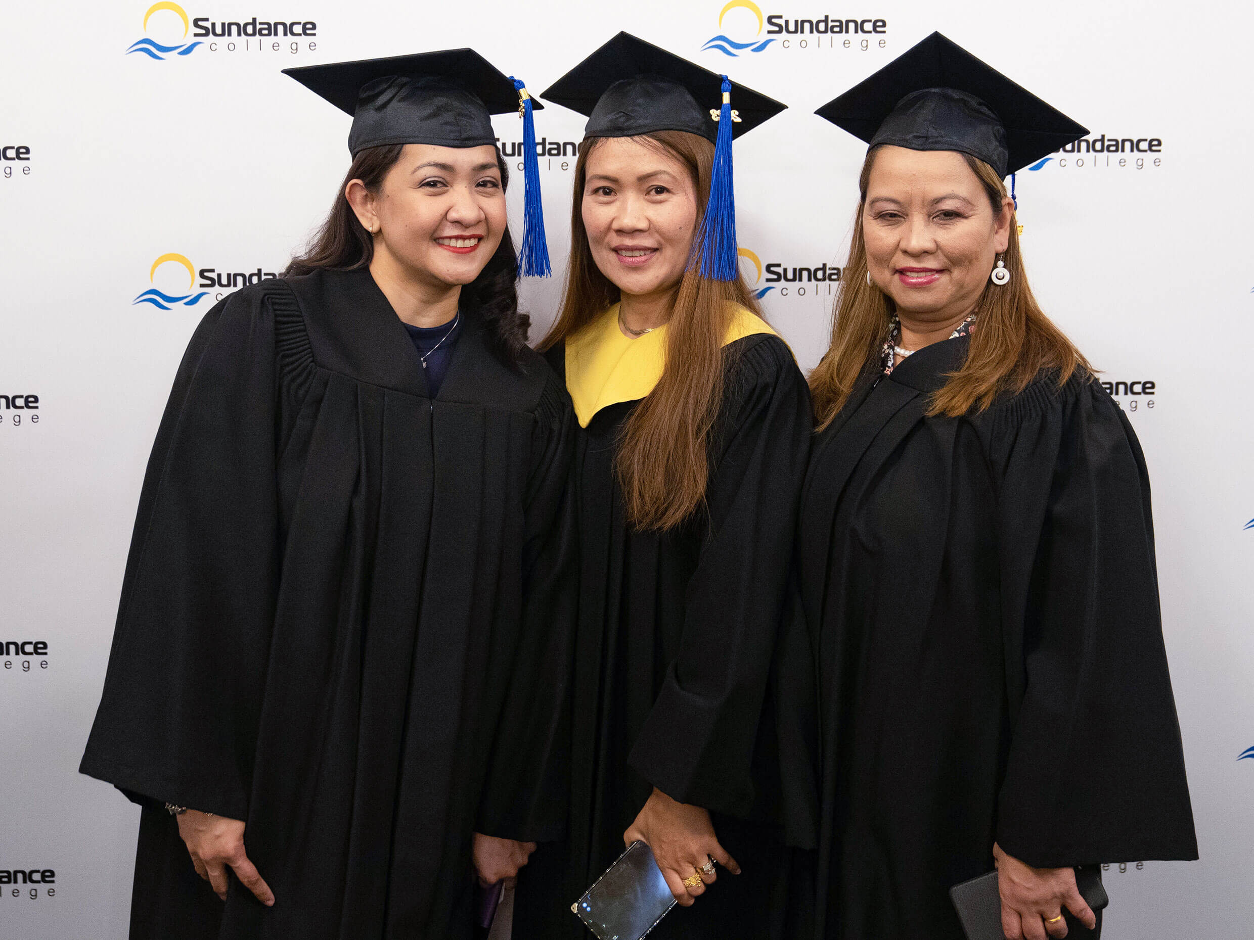 Lalaine P. and fellow happy graduates, in their graduation caps and gowns, posing for a commemorative photograph