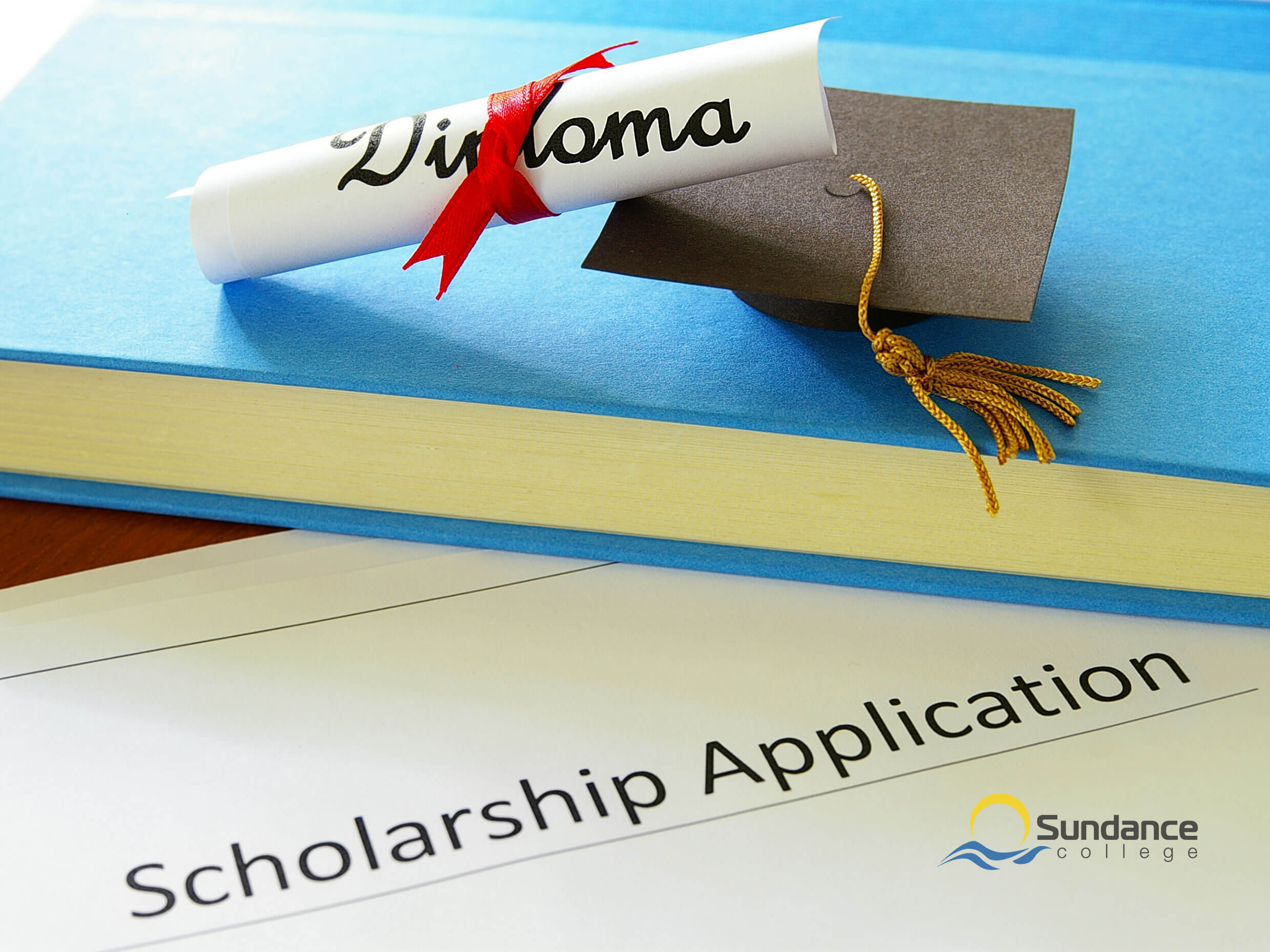 A photo of a diploma resting on a textbook, weighing down a scholarship application form with a Sundance College logo on it
