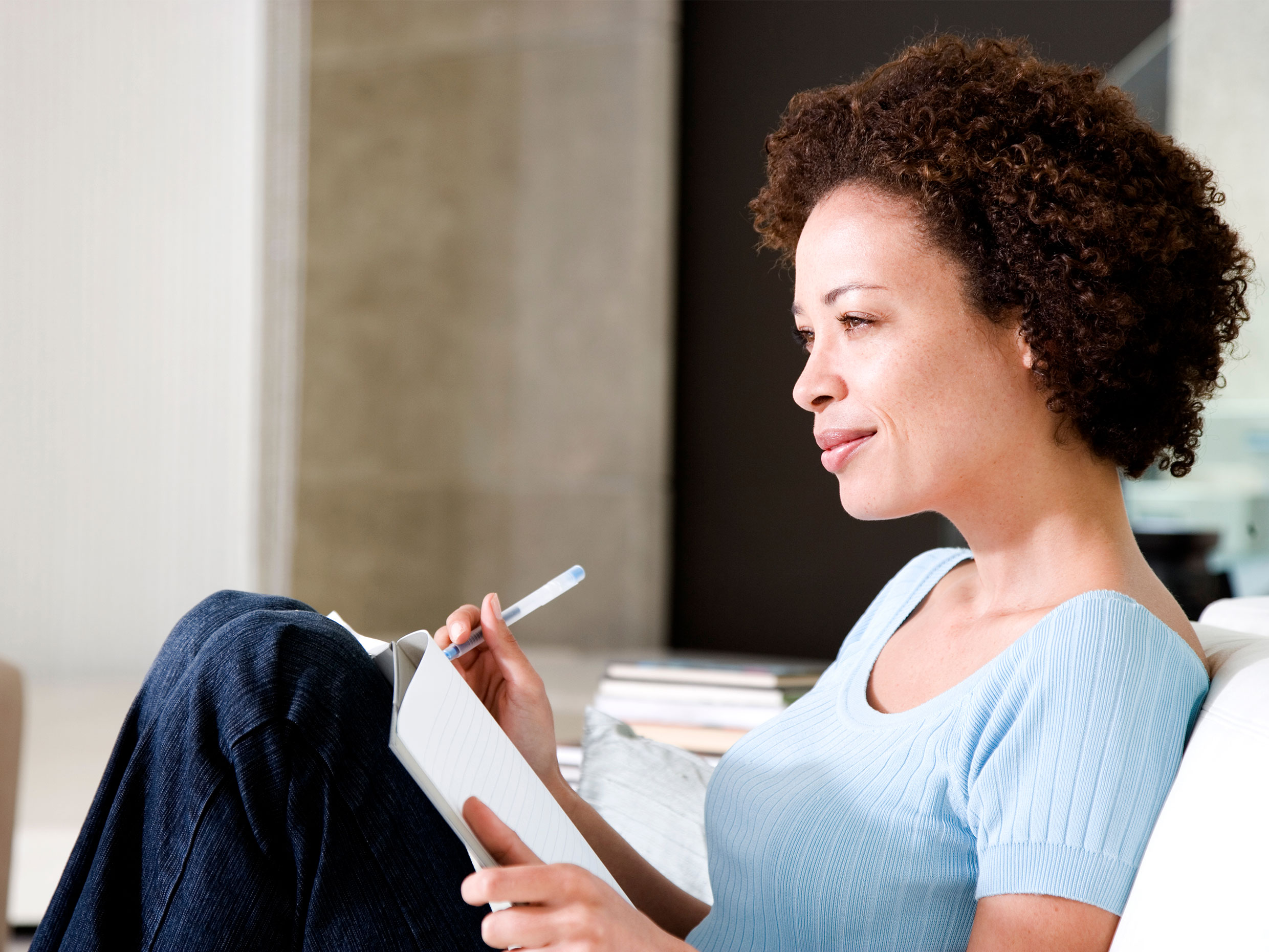 middle aged woman looking reflecting confidently on career options before her with notepad in hand