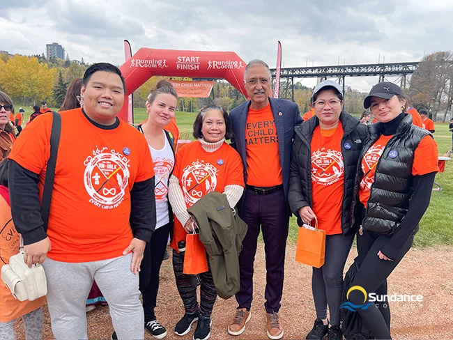 Six members of the Sundance College Edmonton campus team, all wearing orange shirts, participating in the 2023 'Every Child Matters' marathon.