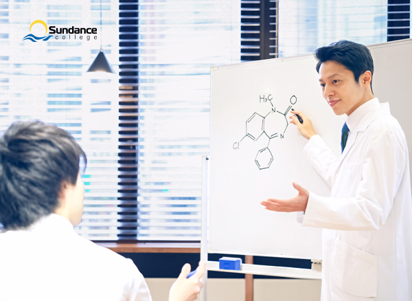 Instructor teaches student pharmacology in a classroom  