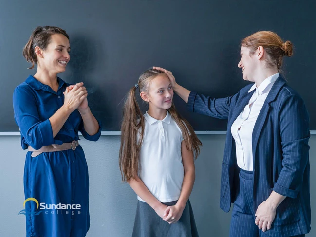 Education assistant gives progress update on student to her mother.