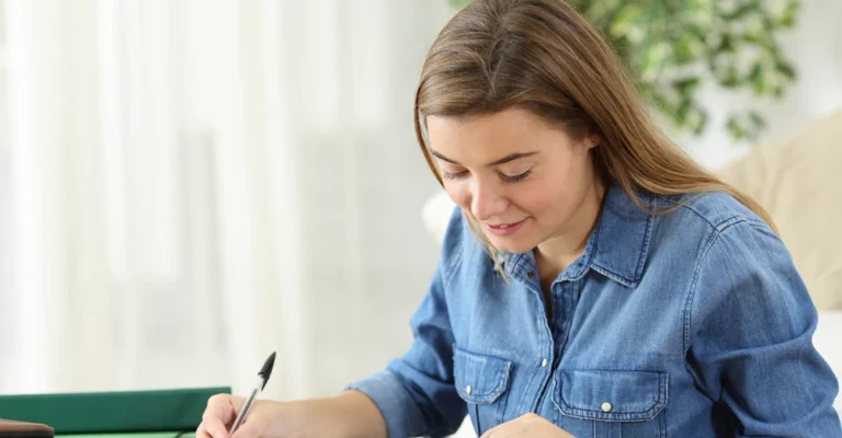 a woman writing on a piece of paper college student budgeting