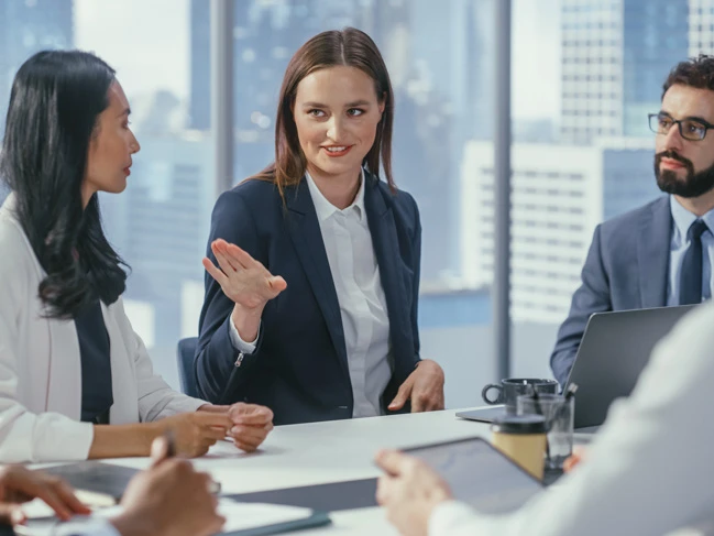 a group of people sitting around a table business manager leading a meeting