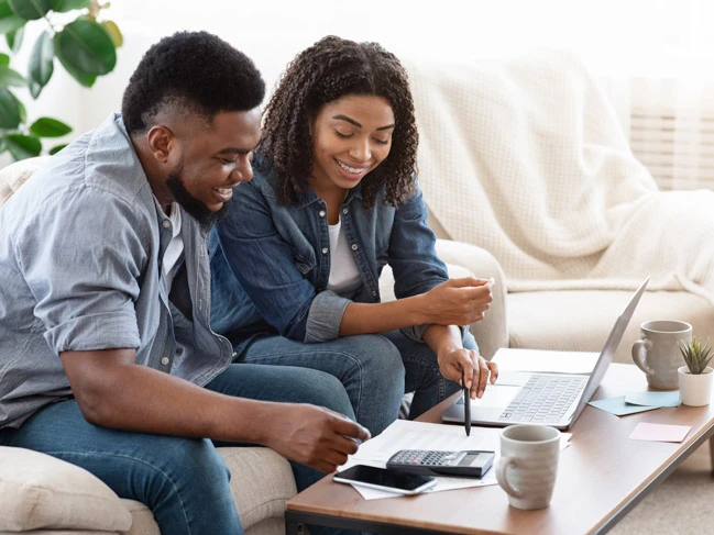 a man and woman looking at a laptop