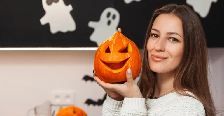 a woman holding a carved pumpkin