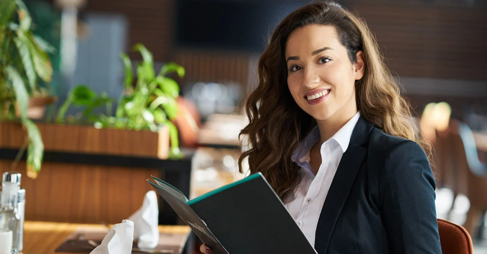 a woman holding a book hospitality industry