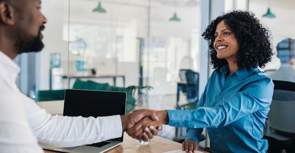a woman shaking hands with a man career in human resources
