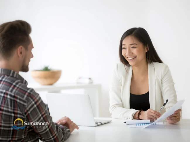 A happy Sundance College Human Resources Professional Diploma graduate providing a job interview with a candidate.