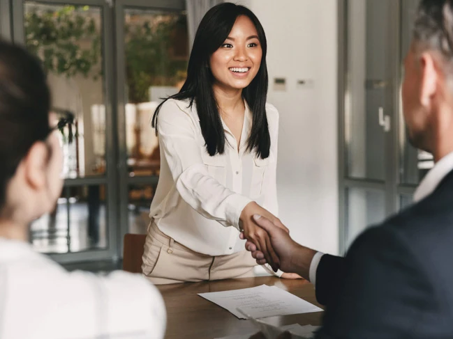 Interviewee shaking hands with company hiring team