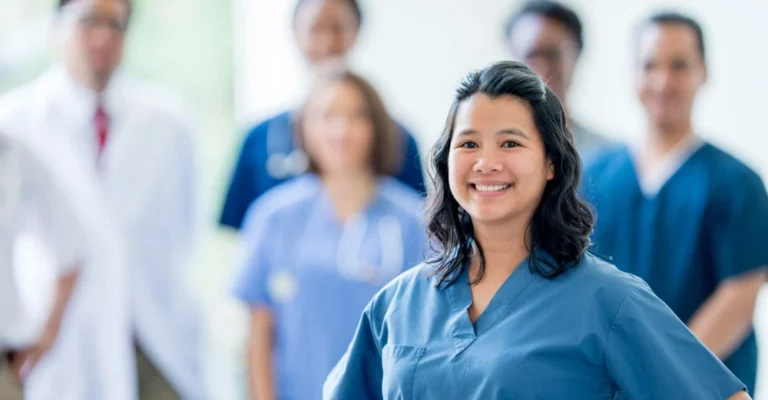 a woman in blue scrubs smiling medical office assistant