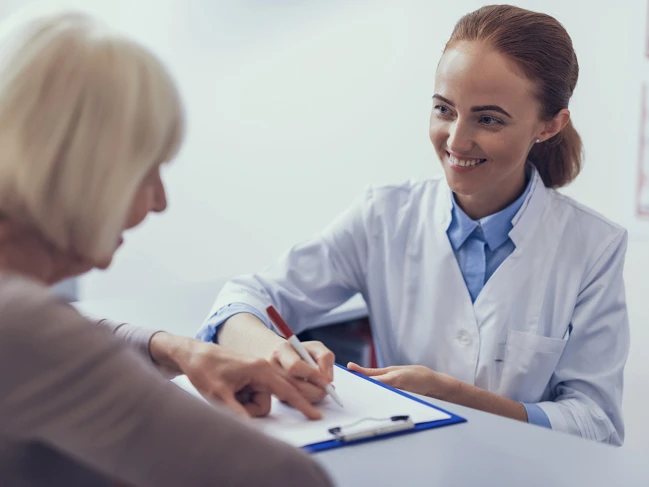 Medical office assistant helping an elderly