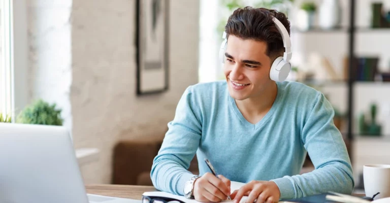 a man wearing headphones and writing on a paper face to face learning