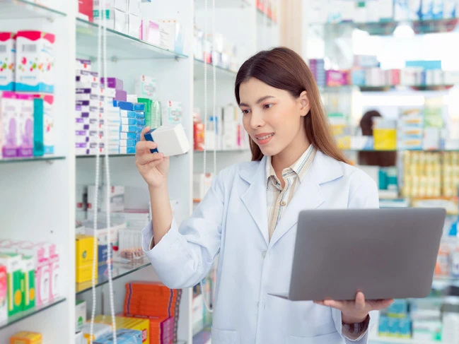 Pharmacy assistant student holding a laptop during a pacticum