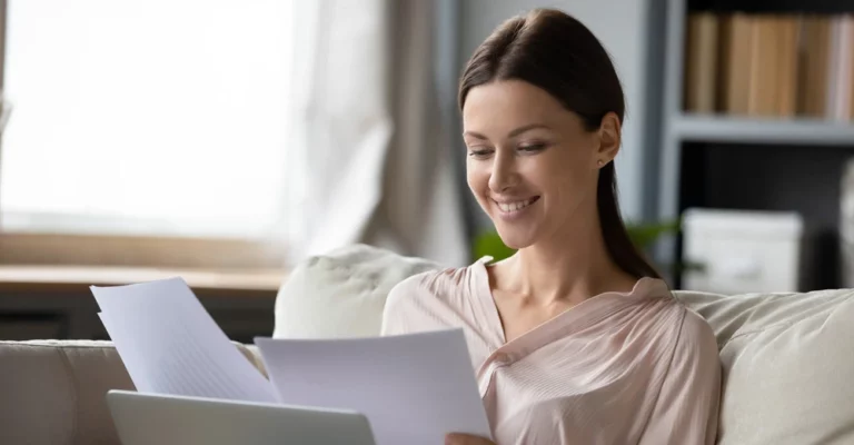 a woman smiling while reading a paper money tips
