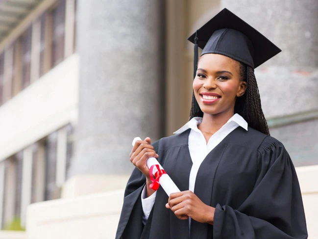 a woman in a graduation gown holding a diploma