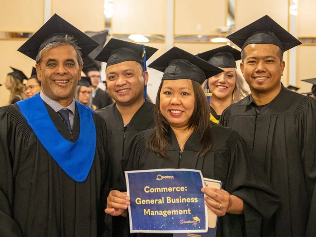 Woman standing with general business management graduates