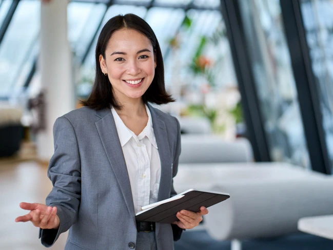 a woman in a suit holding a tablet