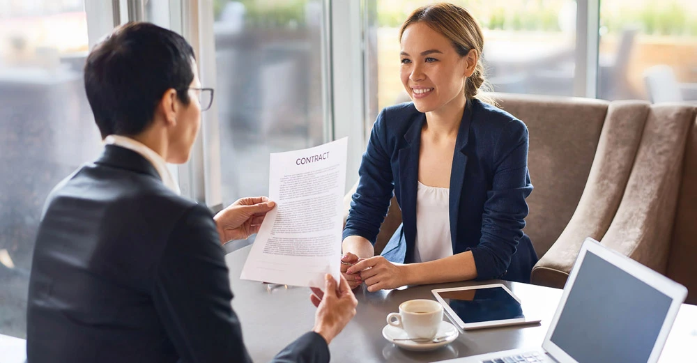 a woman holding a paper to a man