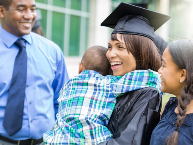 a woman with family at graduation ceremony