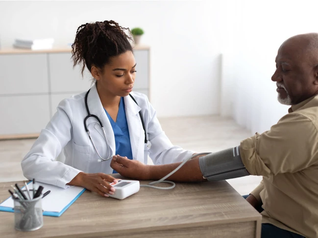 a doctor taking a blood pressure of a man healthcare staff and patient