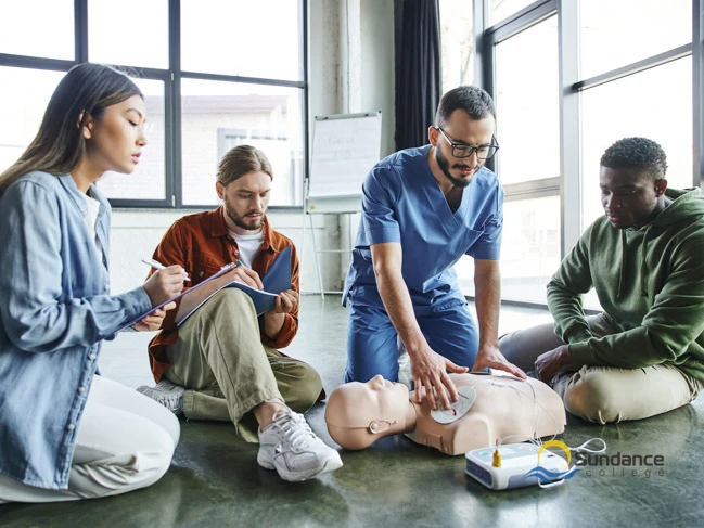 healthcare worker applying defibrillator pads on CPR mannequin 