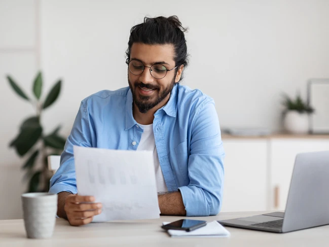 a man sitting at a table reading a paper