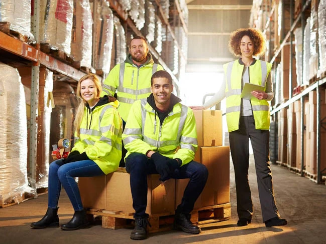 a group of people in safety vests supply chain staff warehouse