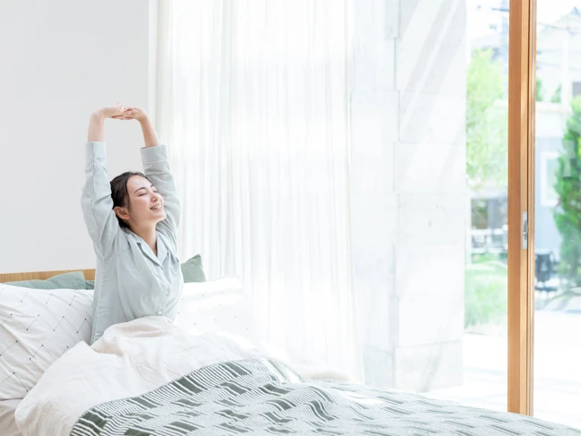 a woman stretching in bed