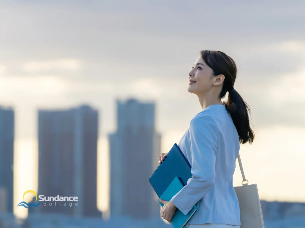 Businesswoman thinking proudly of her progress while leaving work carrying some documents and a bag.