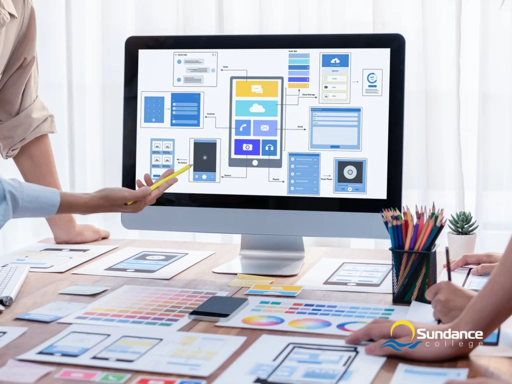 Four employees discussing the design of a website that’s displayed on a nearby computer.