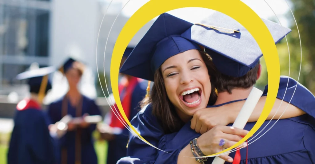 A Sundance College graduate celebrating her graduation by hugging her friend and holding her diploma.