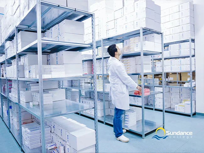 Warehouse pharmacy technician searches for medication on organized shelves.