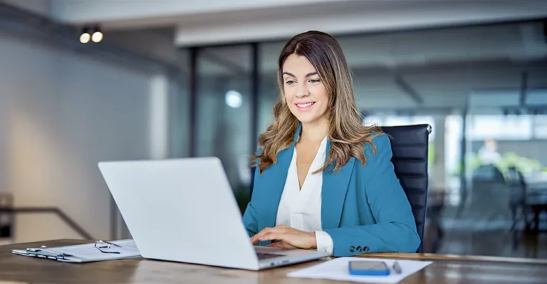 A business manager working on her laptop at her desk in an office setting