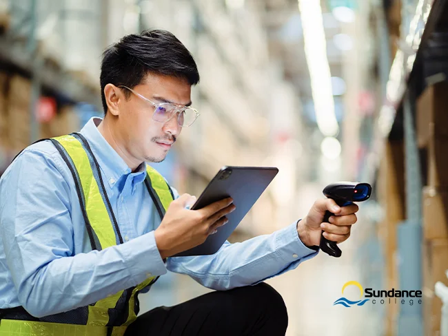  Young male inventory coordinator in a warehouse, scanning products and tracking inventory on a tablet.