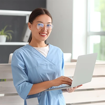 A medical administrator using a laptop.