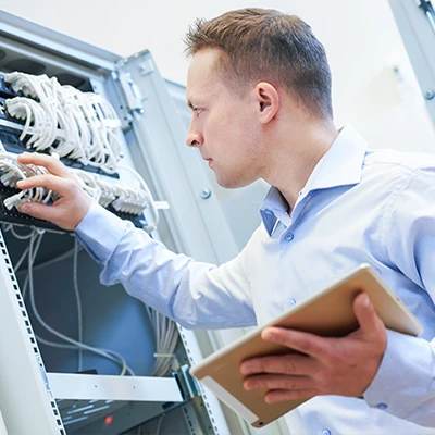 A network technician working in a server room.