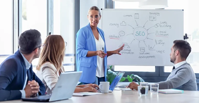 Digital marketer speaking in front of her colleagues during a content strategy planning meeting.