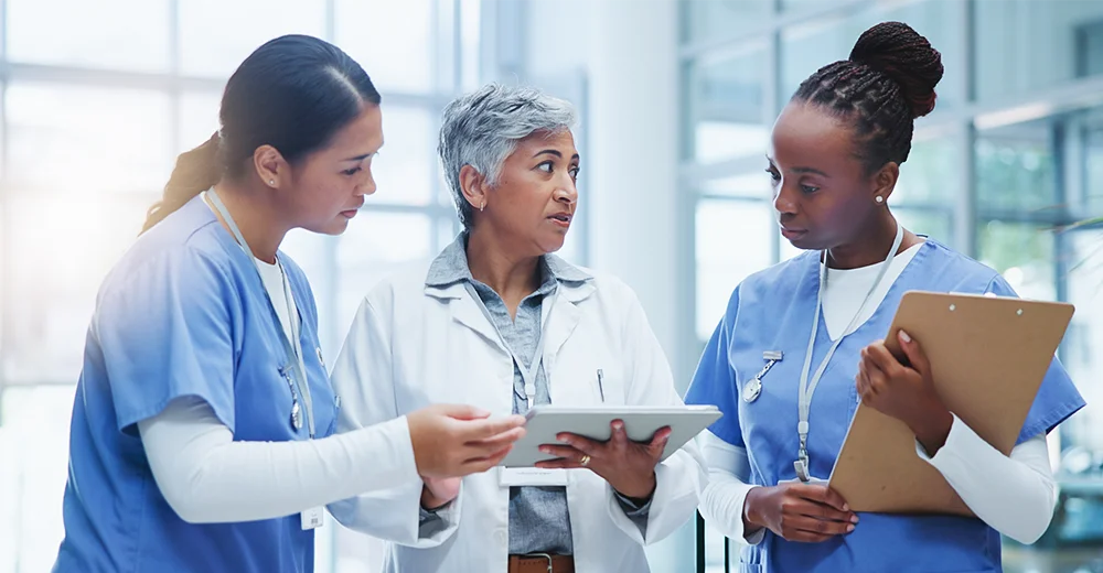 Entry-level healthcare workers in a hospital setting talking to each other.