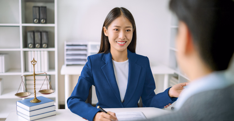 A young woman sits at a desk after choosing a career as a legal assistant.