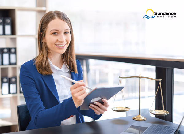 A young woman works with a tablet, an example of a legal assistant working in a professional, structured environment.