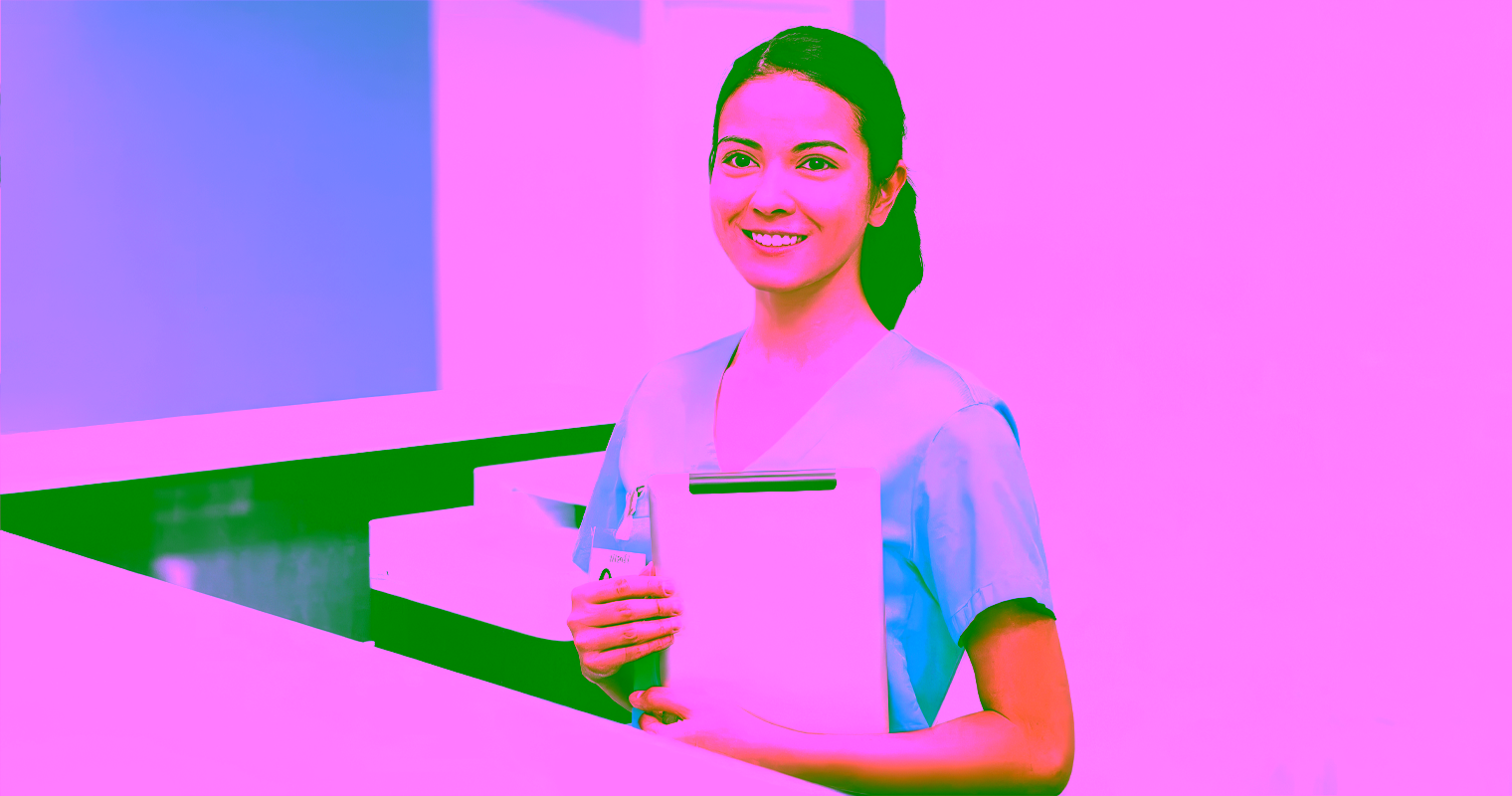 Medical Office Assistant holding a clipboard at the reception area of a hospital.