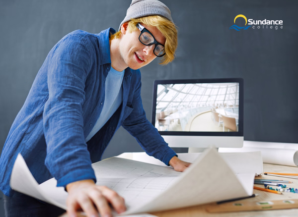 An Architectural Building Technologist examines a construction drawing in his home office.