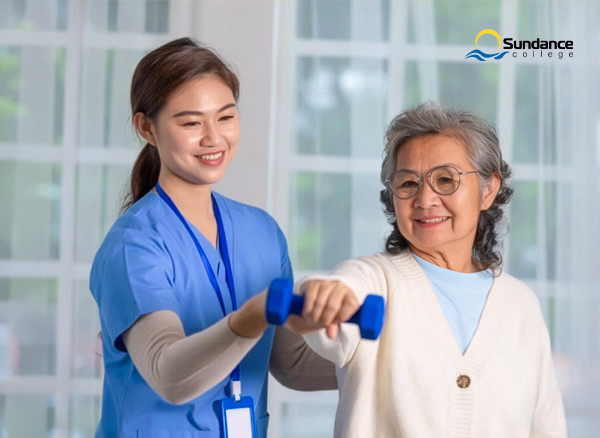 Personal support care worker in blue scrubs assists an elderly client with exercise.