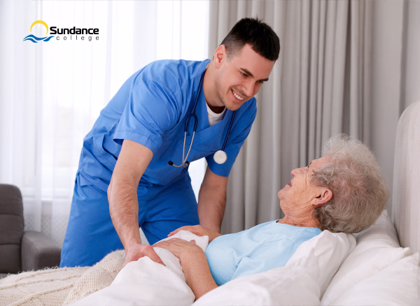 body personal support care worker in blue scrubs tucking an old lady into bed
